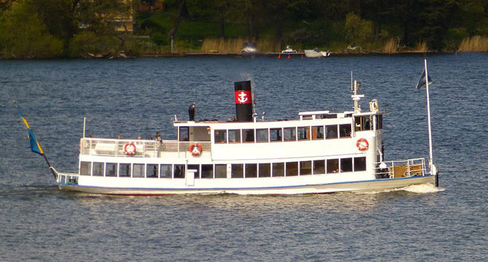 Drottningholm är ett passagerarångfartyg som ligger lågt i vattnet, knappt något skrov syns ovanför vattenytan. Hon har två våningar med bland annat ett soldäck i aktern på det övre. Midskepps syns en svart skorsten med ett rött rederimärke med ett ankare på och i fören syns kommandobryggan.