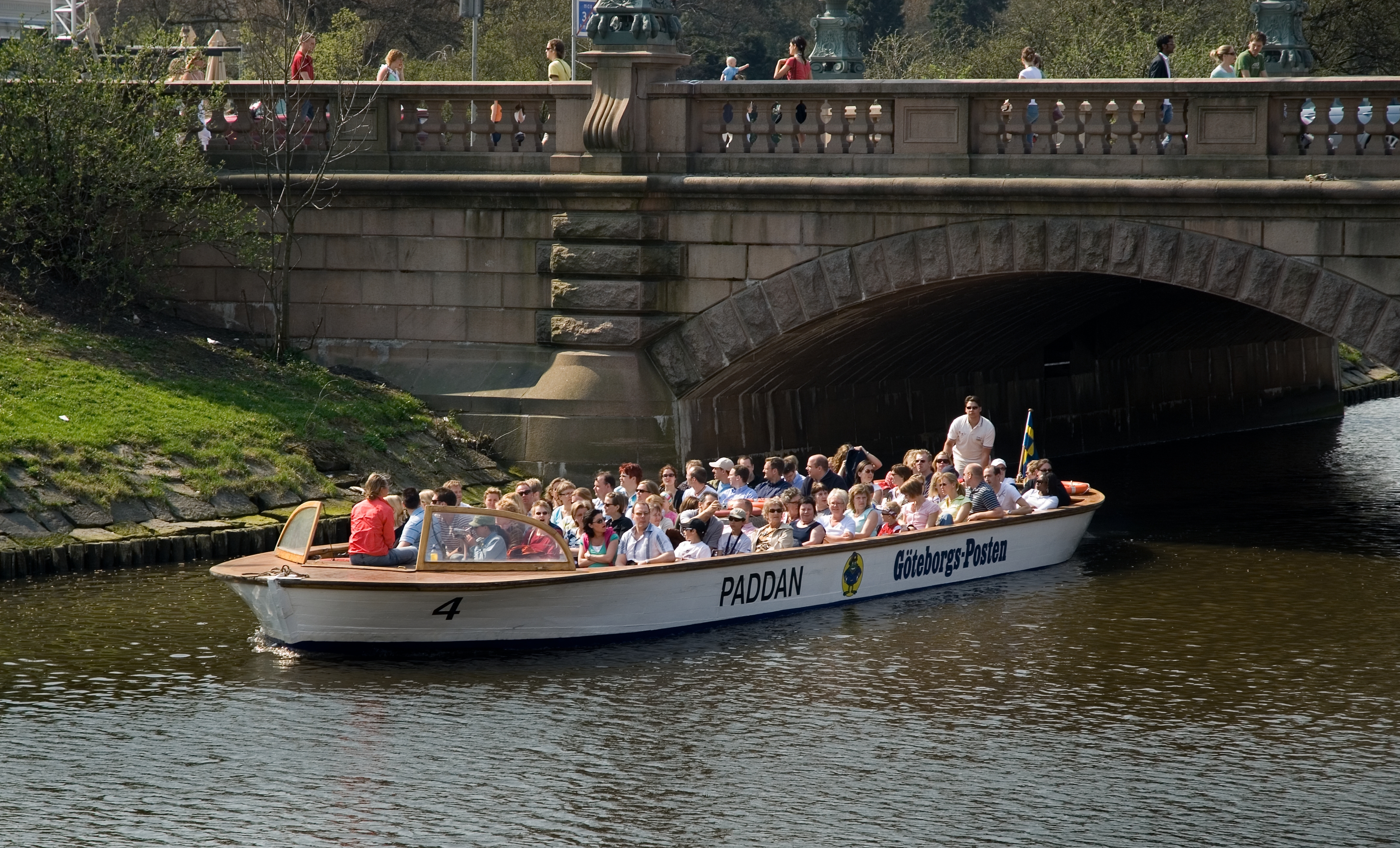 Paddan fyra är en öppen sightseeingbåt. Hon ligger lågt för att komma under broarna och är utformad för att ta många besökare. Hon har två vindrutor i fören som sticker upp. På bilden är fartyget på väg in under ett brovalv i centrala Göteborg. 