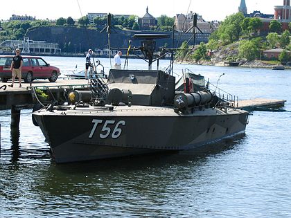 T56 är ett militärt fartyg, en motortorpedbåt med torpedtuber längs med styrhyttens sidor På bilden ligger fartyget vid kaj i centrala Stockholm, i bakgrunden syns Kastellholmen. 