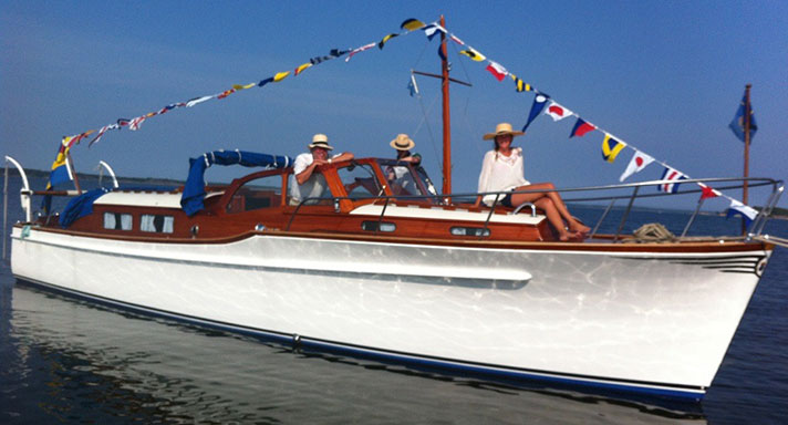 Ingrid är en motorkryssare både för- och akterruff samt styrhytt i mitten. Hennes vita skrov blänker mot vattnet och hennes flaggspel fladdrar i vinden. På båten sitter några ur släkten som har haft henne sedan hon byggdes 1955.