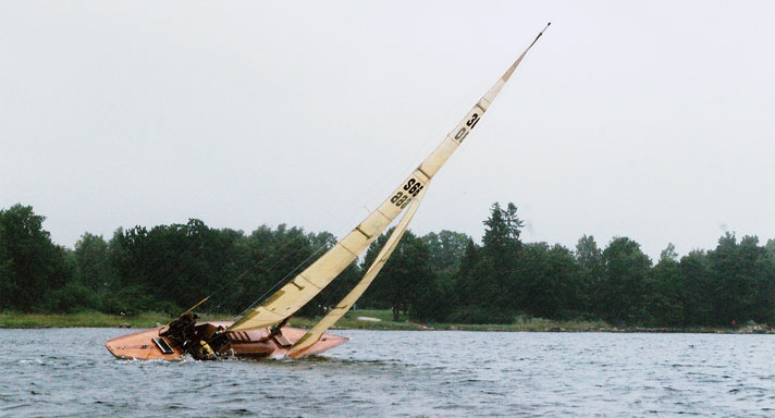 Nornan fyra är en skärgårdskryssare i hondurasmahogny som syns segla i god vind. Hon går i bra fart och har både stor- och förseglen hissade.