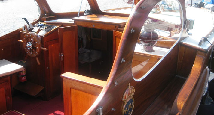 Bilden på motorbåten Sanna visar bara styrplatsen på båten. Båten är byggd i mahogny, även ratten. I mitten syns en nergång till förruffen.