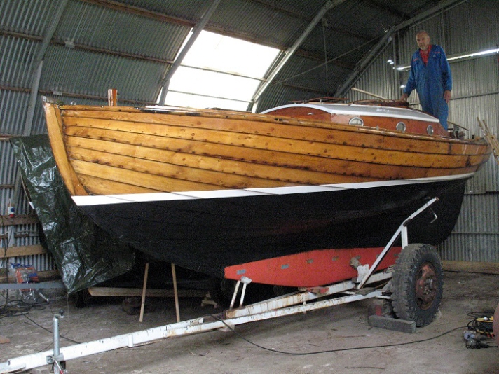 Tärnungen är en klinkbyggd kosterbåt i ek. Hon ligger utan mast i en vagga på varvet och en man står uppe i sittbrunnen på bilden.