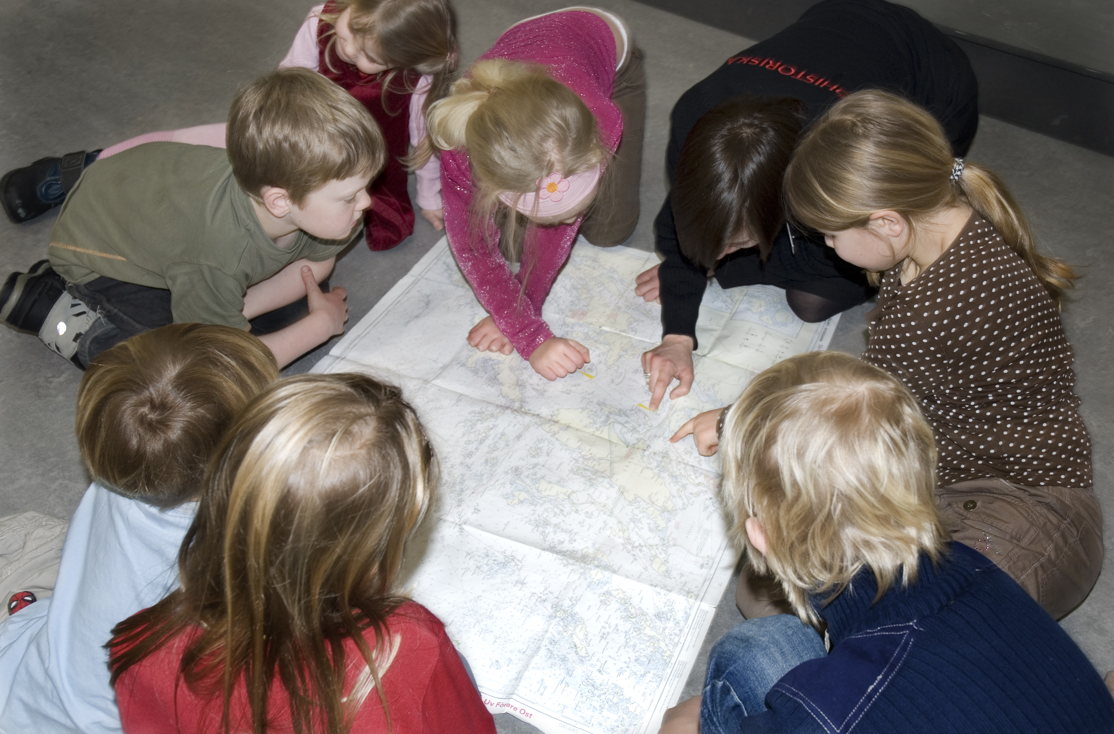 Elever som tittar på ett sjökort tillsammans med sin lärare.